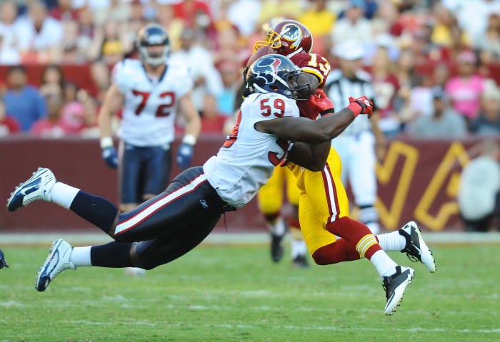 Redskins wide receiver Anthony Armstrong (13) catches a pass as Houston Texans linebacker DeMeco Ryans (59) defends in the second half at FedEx Field.